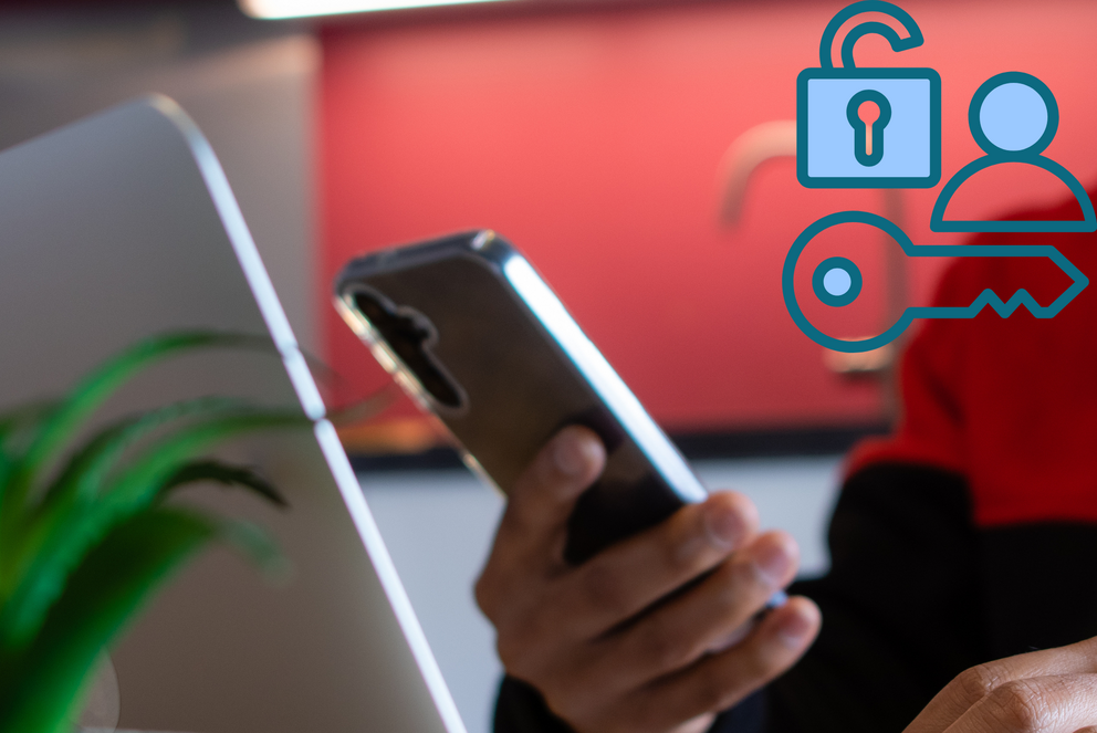 Mensch tippt etwas ins Handy und in den Laptop